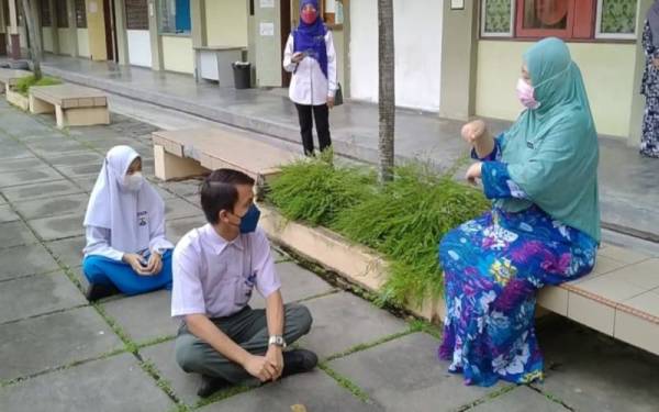 Norul Huda (kanan) memberikan taklimat dalam bahasa isyarat kepada Muhammad Hazami dan Nurul Aina Natasya sebelum masuk ke dalam dewan peperiksaan SPM di SMK Tasek Damai di sini pada Rabu.