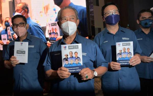 Muhyiddin menunjukkan buku Ikrar Perikatan Nasional 'Demi Bangsa Johor' yang dilancarkannya di sebuah hotel di Johor Bahru hari ini. - Foto Bernama