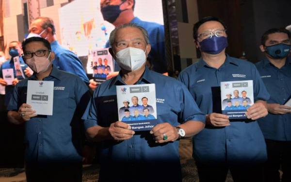 Muhyiddin menunjukkan buku Ikrar Perikatan Nasional Demi Bangsa Johor yang dilancarkannya di sebuah hotel pada Rabu.