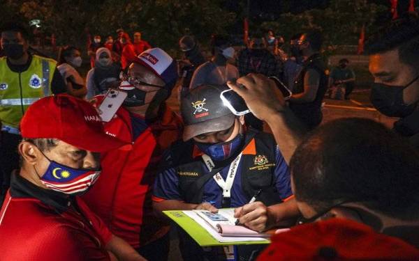 Pegawai Jabatan Kesihatan mengeluarkan kompaun kepada menganjur Ceramah Mega Pakatan Harapan kerana tidak mematuhi prosedur operasi standard (SOP) ketika melakukan pemeriksaan SOP di Ceramah Mega Pakatan Harapan di Bilik operasi Utama Pakatan Harapan Dewan Undangan Negeri (DUN) N.49 Kota Iskandar malam Rabu. - Foto Bernama 