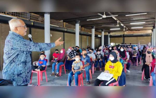 Mahfuz (kiri) di Program Bantuan Awal Persekolahan Dewan Undangan Negeri (DUN) Bukit Pinang di Hutan Kampung, Alor Setar pada Jumaat.