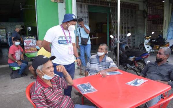 Mohd Hasnolhadi (berdiri, dua dari kiri) menyantuni pengundi di kedai makan. Sumber Foto: Mohd Hasnolhadi