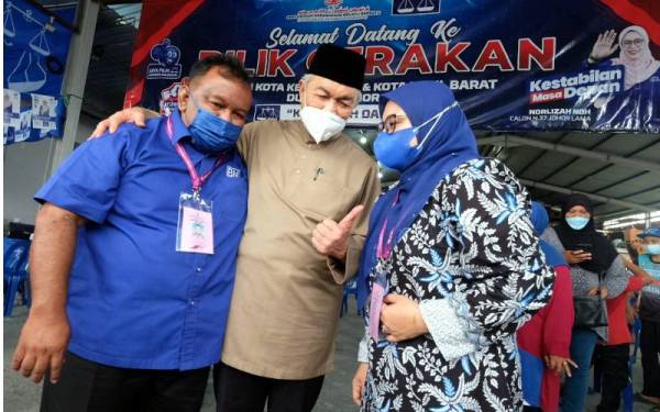 Dr Ahmad Zahid Hamidi (tengah) beramah mesra dengan calon BN N36 Sedili Muszaidi Makmor (kiri) dan calon BN N37 Johor Lama, Norliza Noh semasa mengadakan lawatan kerja ke Pusat Daerah Mengundi (PDM) Kota Kecil Timur 004 pada Jumaat. - Foto Bernama