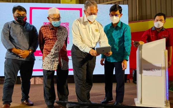 Mustapa (tiga dari kiri) bersama Hanifa (dua dari kiri) merasmikan Majlis Pelancaran Program Transformasi Digital Pasar Besar Siti Khadijah, di Kota Bharu pada Ahad.