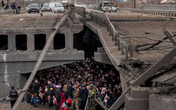 Penduduk Ukraine berlindung di bawah sebuah jambatan yang musnah ketika mereka cuba menyeberangi Sungai Irpin di pinggir ibu kota. - Foto: Agensi