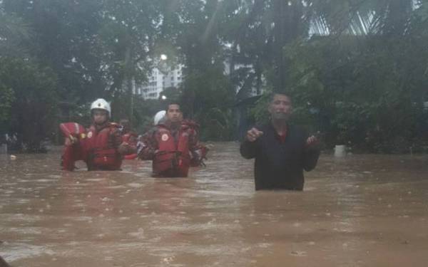 Anggota bomba menyelamatkan mangsa banjir di Kampung Pasir Pantai Dalam pada Isnin.