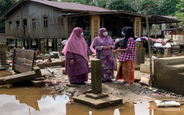 Zailah (kiri) dan Mumtaz (tengah) bertanya khabar Che Hasniza yang kehilangan rumah ketika banjir baru-baru ini.