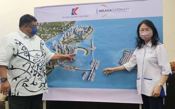 Ab Rauf (kiri) dan Michelle Ong menunjukkan pelan pembangunan PME1 di Pulau Melaka pada Selasa.