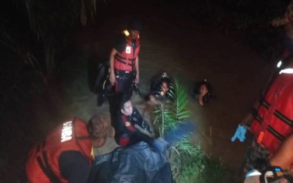 Anggota bomba mengangkat remaja yang lemas di sebuah sungai di Estet Gemas Baru, Gemas, Segamat pada awal pagi Khamis