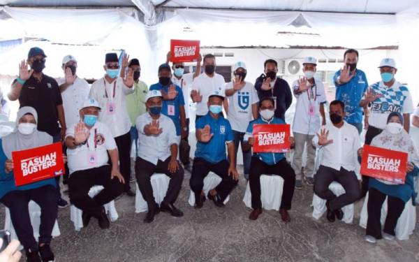 Calon-calon Pejuang yang bertanding pada PRN Johor menunjukkan simbolik menolak rasuah dan menunjukkan plakad Rasuah Busters ketika di Felda Ayer Hitam, Kluang, Johor, baru-baru ini.