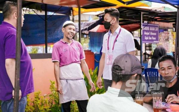 Muhammad Saiful Bahari (kanan) ketika beramah mesra bersama peniaga ketika berkempen di Stulang.