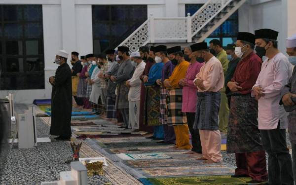 Ikmalrudin(dua, kanan) menunaikan solat Hajat sempena majlis bacaan Yassin, doa selamat dan solat hajat yang dipimpin oleh Imam Dua Masjid Habib Hassan Al-Attas Muhammad Asyraf Hairam (kiri), pada Khamis. Foto Bernama
