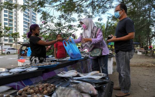 Peniaga di Pasar Pagi Orang Asli, Aisah Rahman, 19, sedang sibuk melayani pelanggan yang hadir ketika tinjuan Bernama di sini, baru-baru ini. - Foto Bernama