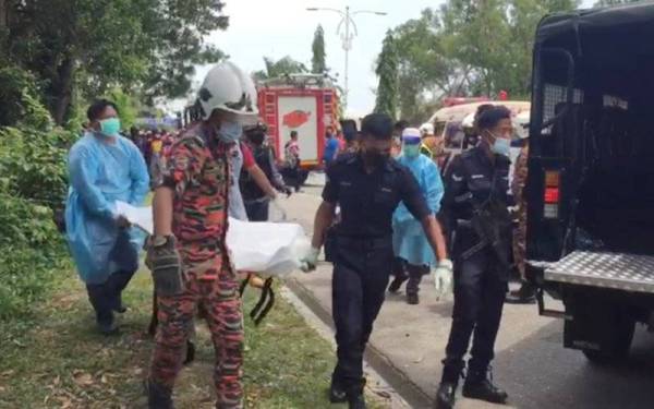 Anggota keselamatan mengangkat mayat mangsa nahas dalam kemalangan membabitkan tiga kenderaan di Jalan Tengku Mizan dekat Kampung Bukit Tunggal pada Sabtu. - Foto ihsan pembaca