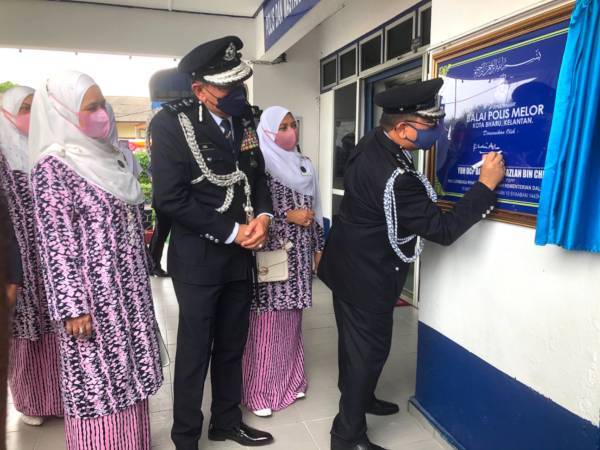 Khalil Azlan (kanan) menandatangani plak sempena Perasmian Balai Polis Melor di Kota Bharu sambil disaksikan Timbalan Ketua Polis Kelantan, Datuk Muhamad Zaki Harun (dua dari kiri). - Foto SINAR HARIAN