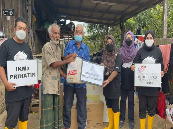 Mohammed (tiga dari kiri) menyampaikan sumbangan kepada salah seorang mangsa banjir.