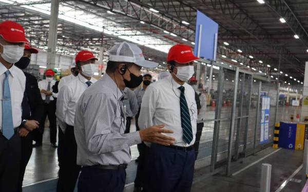 Abe (kanan) diberi penerangan sempena lawatan ke kilang UMW Toyota Motor di Bukit Raja, pada Sabtu lalu.