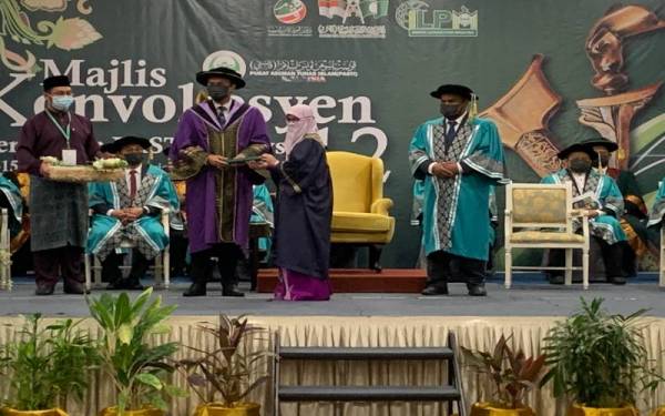 Muktar (dua dari kiri) menyampaikan Diploma Pendidikan Awal Kanak-kanak kepada guru yang terlibat di Majlis Konvokesyen Perguruan Pasti Malaysia ke-12, pada Selasa.