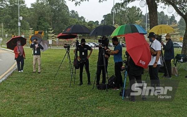 Petugas media menunggu di hadapan perkarangan pintu masuk Istana Bukit Serene.