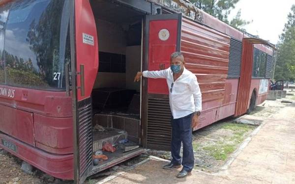 Mohd Yusof menunjukkan salah sebuah bas lama yang tidak lagi digunakan dan menjadi tempat pembuangan sampah.