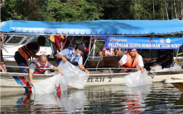 Ruzaidi (dua dari kanan) ketika pelepasan benih ikan dan udang di Sungai Leban Kerbat, Tasik Kenyir, pada Selasa.