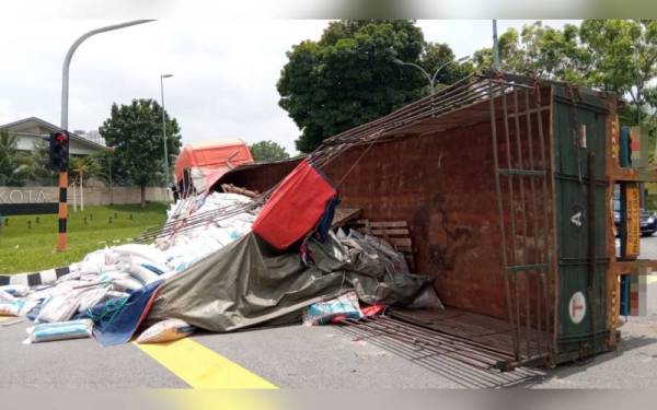 Lori yang membawa muatan baja terbalik dalam kejadian di persimpangan lampu isyarat di Tol Seri Putra, Kajang pada Selasa.