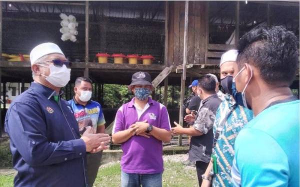 Razman (kiri) ketika meninjau operasi ladang ternakan ayam di Batu 2 Kampung Changkat Lobak, pada Khamis.