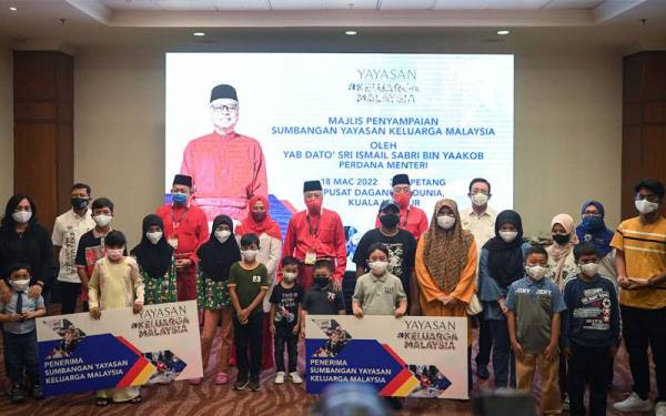 Ismail Sabri (belakang tengah) bergambar bersama penerima bantuan Yayasan Keluarga Malaysia di Pusat Dagangan Dunia Kuala Lumpur pada Jumaat. - Foto Bernama