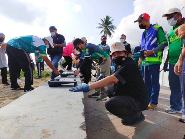 Dr Izani (kanan) turut serta ketika program gotong-royong pesisir pantai 'Pakak Maghi Bersih Pata Kito' di Pantai Cahaya Bulan, Kota Bharu pada Sabtu.