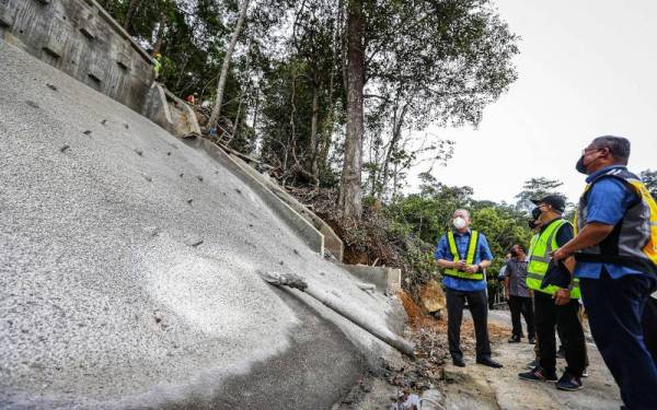 Fadillah (kiri) meninjau kerja-kerja pembaikan cerun pasca banjir di Jalan Gunung Jerai di Gurun, Kedah pada Sabtu.