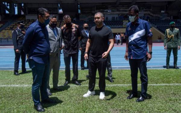 Tunku Ismail (dua dari kanan) berkenan mencemar duli hadir meninjau keadaan padang di Stadium Nasional Bukit Jalil pada Sabtu.   Turut sama Ahmad Faizal (kiri).   - Foto Bernama