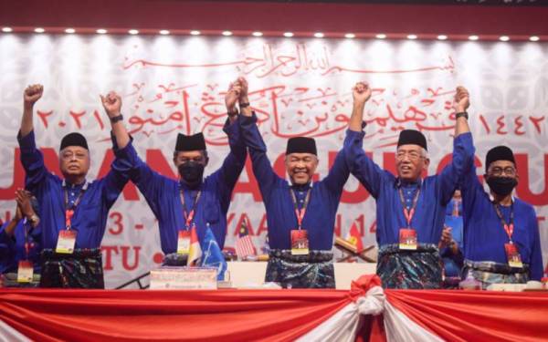 Ismail Sabri, Mohamad Hasan, Ahmad Zahid Hamidi, Mahdzir Khalid dan Mohamed Khaled menjulang tangan mereka selepas selesai ucapan penangguhan pada Perhimpunan Agung UMNO (PAU) 2021 di WTCKL pada Sabtu. - Foto Bernama