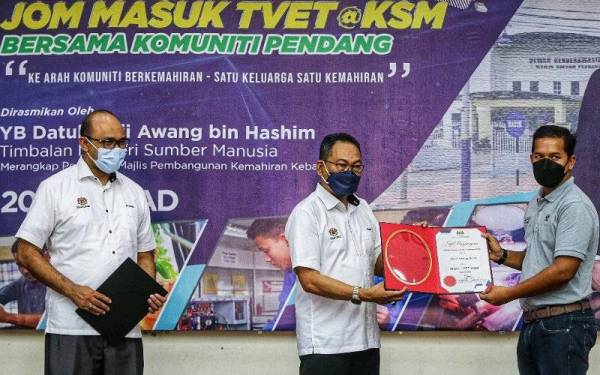 Awang (tengah) menyampaikan sijil Ikon TVET KSM kepada salah seorang penerima pada majlis perasmian Program Jom Masuk TVET@KSM di Dewan Cenderawasih di sini pada Ahad.