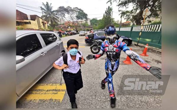 Optimus Prime menyambut murid datang ke sekolah.