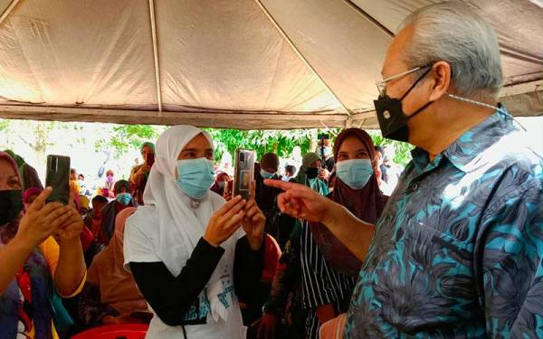 Annuar (kanan) beramah mesra dengan mangsa banjir di Kampung Serongga, Repek, Pasir Mas pada Isnin.