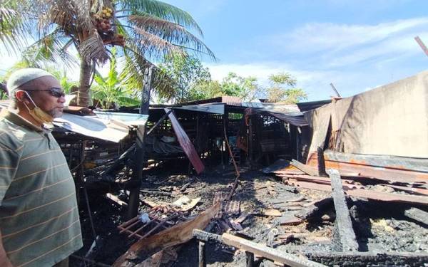 Badrishah merenung keadaan kandang ternakannya yang terbakar hingga mengakibatkan 35 ekor kambing mati dalam kejadian di Dataran Pengkalan Barat 16, Taman Temara, Ipoh pada Ahad.