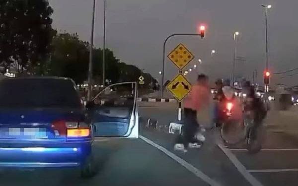 Tangkap layar rakaman video pemandu kereta memukul seorang penunggang basikal di persimpangan lampu isyarat yang tular di media sosial.