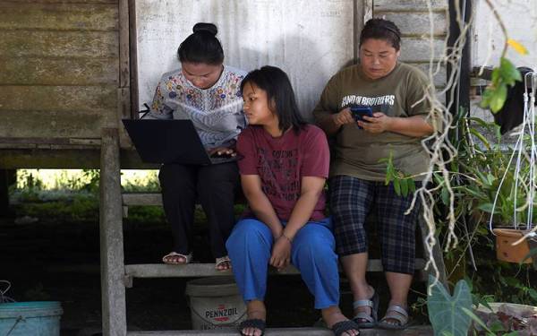 Rokna (kiri) kini tidak lagi mengalami masalah untuk mengikuti kuliah secara dalam talian selepas pelaksanaan Jendela di Perkampungan Orang Asli Sungai Judah, Selangor.