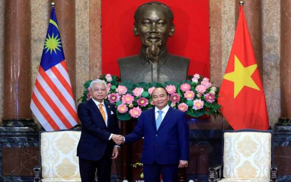 Ismail Sabri (kiri) bersalaman dengan Nguyen Xuan Phuc ketika kunjungan hormat ke atas Presiden Vietnam di Istana Presiden, pada Isnin. - Foto Bernama