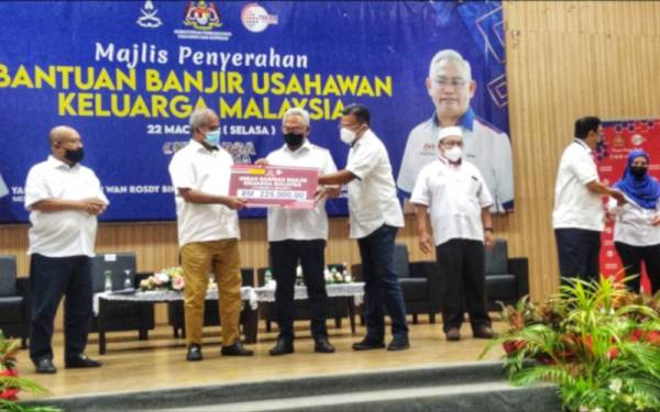 Noh (tiga dari kiri) menyerahkan geran Bantuan Banjir Keluarga Malaysia (BBKM) bagi Parlimen Jerantut yang diterima oleh Exco Hal Ehwal Felda, Koperasi, Usahawan dan Hal Ehwal Pengguna Pahang, Datuk Nazri Ngah (dua dari kiri) di Dewan Tun Razak, Temerloh pada Selasa.