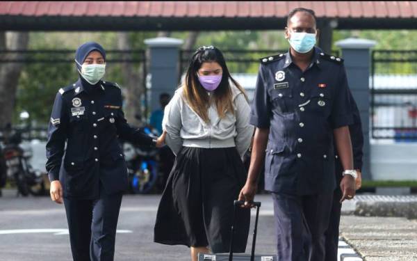 Yap Ping Eng (tengah) diiring polis sebaik tiba di Mahkamah Sesyen Seremban pada Rabu.