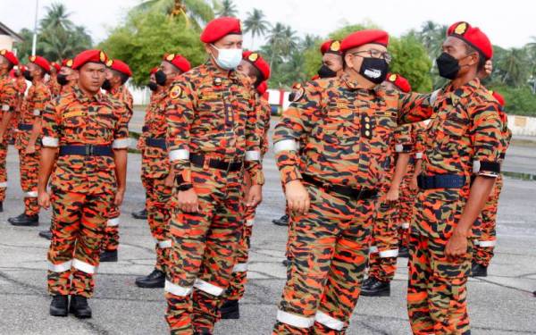 Zainal (dua, kanan) membetulkan beret seorang anggota sewaktu memeriksa barisan kehormat Majlis Tamat Latihan Kursus Pentauliahan Pegawai Bomba Bantuan (PBB) Siri 1/2022 di Pusat Latihan Negeri, Balai Bomba dan Penyelamat Bachok, pada Rabu. - Foto Bernama