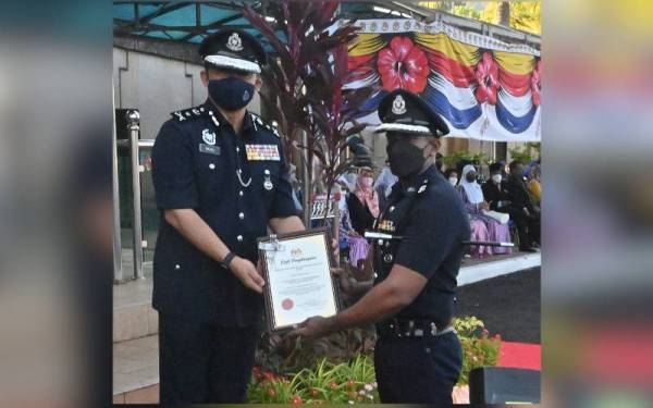 Razali (kiri) menyampaikan sijil penghargaan SPRM kepada SThyagaraj ketika sambutan Peringatan Hari Polis ke-215 peringkat negeri di Ibu Pejabat Polis Kontinjen (IPK) Melaka di Bukit Beruang pada Jumaat.