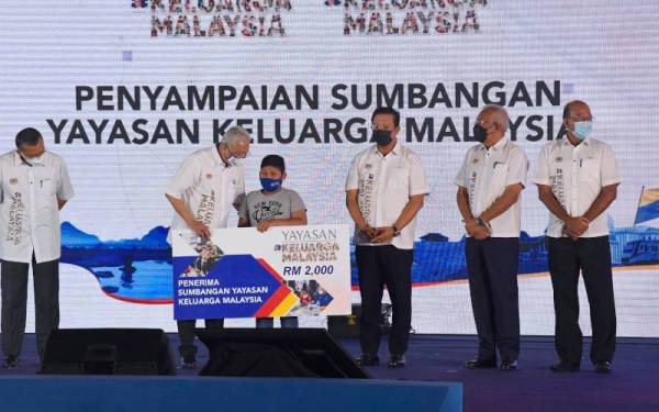 Ismail Sabri menyampaikan sumbangan Yayasan Keluarga Malaysia kepada penerima pada Majlis Perasmian Program Jelajah Aspirasi Keluarga Malaysia Negeri Perlis di Kompleks Sukan Tuanku Syed Putra pada Jumaat. - Foto Bernama