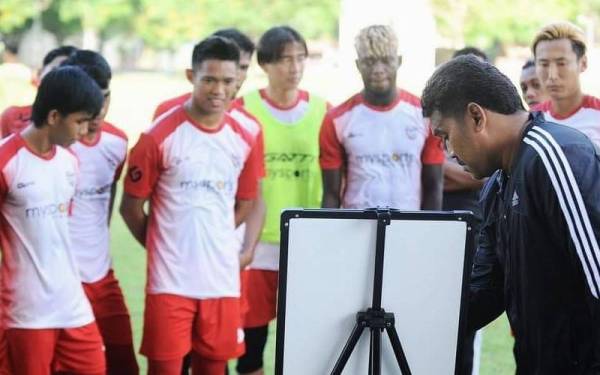 Syamsul (kanan) memberikan taklimat kepada pemain Kelantan United menjelang pertemuan dengan PDRM di Stadium Cheras, pada Ahad. - Foto Kelantan United FC