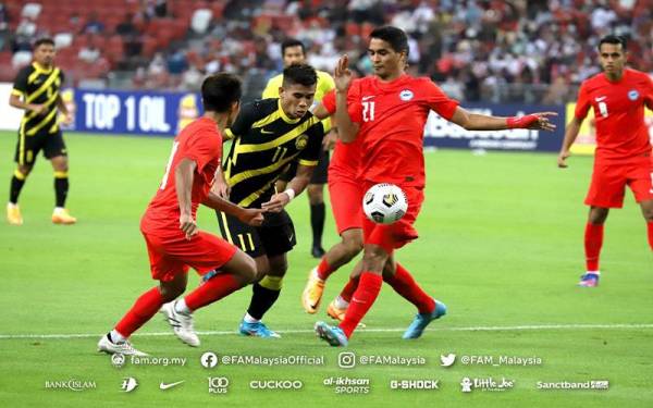 Safawi diasak dua pertahanan Singapura dalam aksi persahabatan di Stadium Nasional, Singapura sebentar tadi. - Foto FB FAM