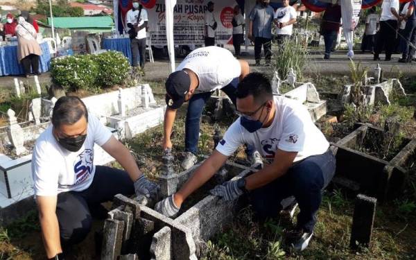 Mohd Hairi (kanan) dan On (kiri) membersihkan kawasan kubur dalam program Ziarah Pusara Peringkat Negeri Menjelang Ramadan di Tanah Perkuburan Islam Kampung Kurnia, Larkin, Johor Bahru, pada Ahad.