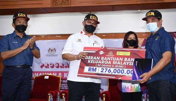  Noh Omar (dua dari kiri) menyampaikan replika cek bantuan kepada wakil daerah Jelebu, Mohd Razi Ali (kanan) pada Program Usahawan dan Keluarga Malaysia di Simpang Pertang pada Ahad. -Foto Bernama 