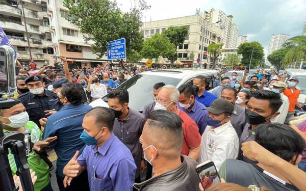 Orang ramai menyambut Najib ketika hadir ke Jelutong Jumaat lalu.