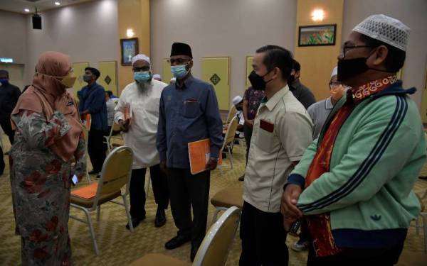 Hakimah (kiri) beramah mesra bersama sebahagian guru-guru pada Majlis Perasmian Simposium Guru-Guru Mualaf Peringkat Kebangsaan Kali Pertama Tahun 2022 di Masjid Tuanku Mizan Zainal Abidin hari ini. Foto Bernama